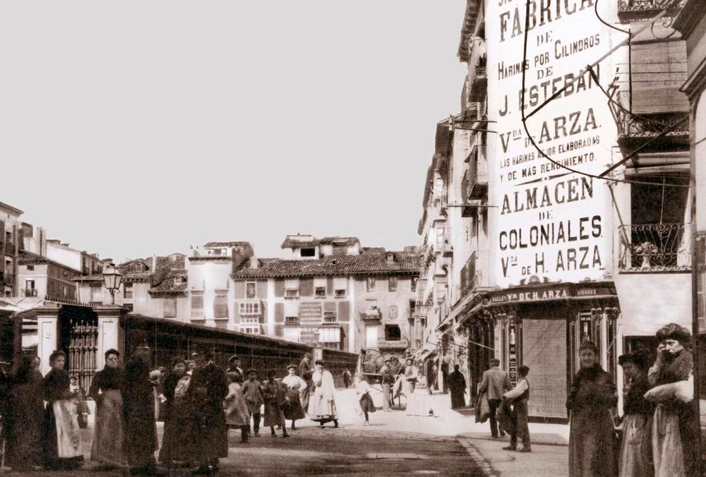 Estampa cotidiana de principios del siglo XX de la Plaza de la Verdura, con los viejos puestos, antepasados del actual Mercado de Abastos.