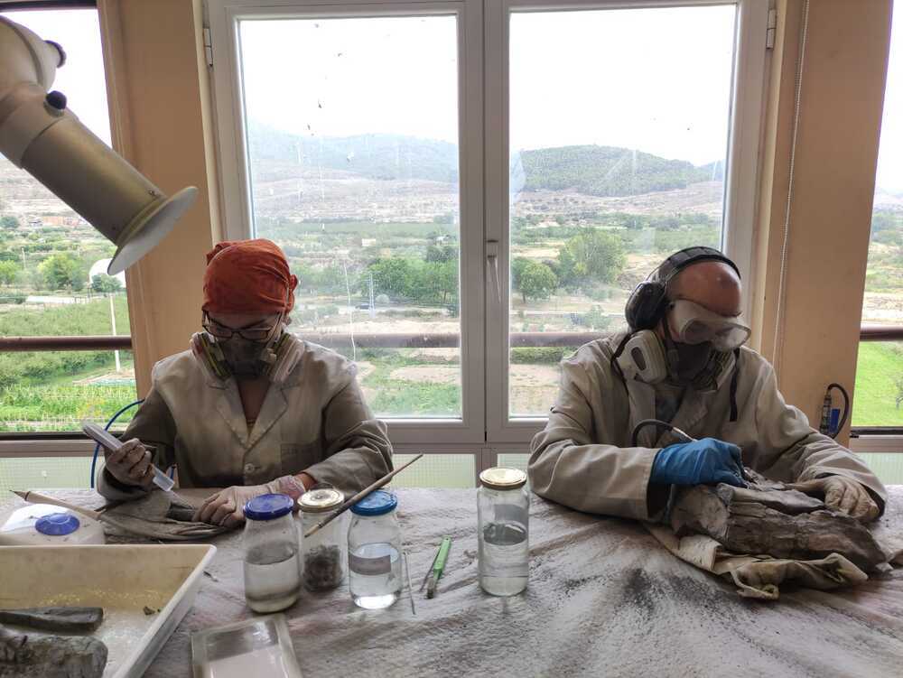 En la imagen, los dos restauradores trabajan recuperando los restos fósiles de 'Garras'.