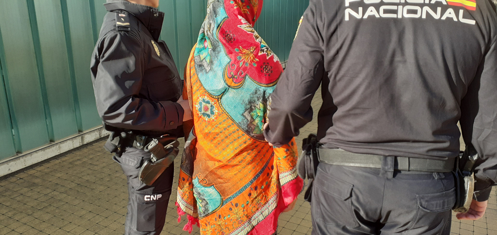 Dos agentes conducen a la mujer detenida a la Jefatura de Policía.