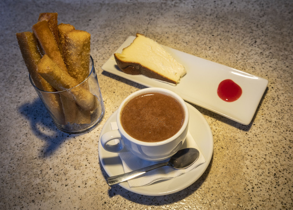 BAR VENTO. Tarta de queso (2,00 euros) y chocolate a la taza con picatostes (3,90 euros).