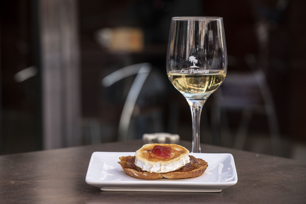 LAS PALMERAS. Tosta de rulo de queso de cabra con cebolla caramelizada y confitura de tomate (2,20 euros) y copa de vino blanco Rioja (1,20 euros). En 'pinchopote', pincho y vino: 2 euros.