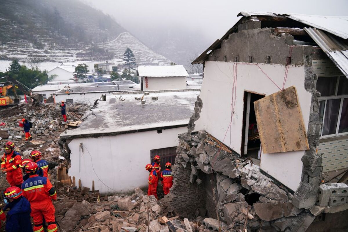 Rescue workers search for survivors near damaged houses after a landslide hit Zhenxiong county in Zhaotong  / STRINGER
