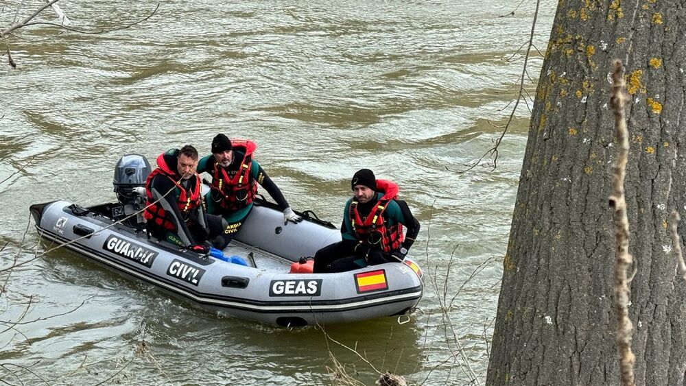 Efectivos del grupo GEAS de la Guardia Civil rastrean el Ebro con un bote.